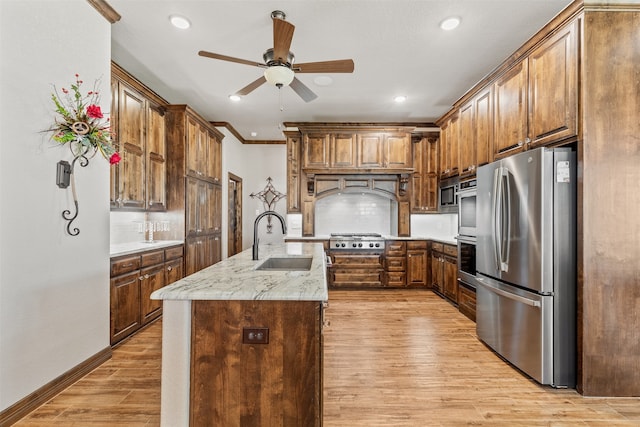 kitchen featuring sink, appliances with stainless steel finishes, light hardwood / wood-style flooring, crown molding, and decorative backsplash