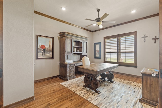 home office with ceiling fan, a textured ceiling, light wood-type flooring, and crown molding