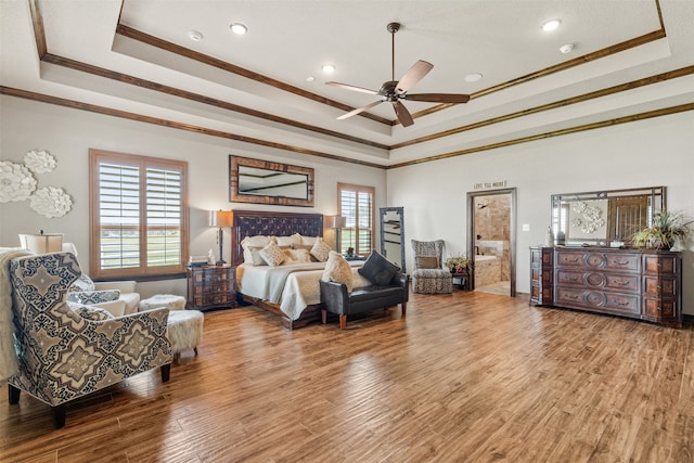 bedroom with ceiling fan, a raised ceiling, light wood-type flooring, and crown molding