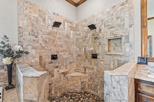 bathroom featuring ornamental molding, vanity, and a tile shower