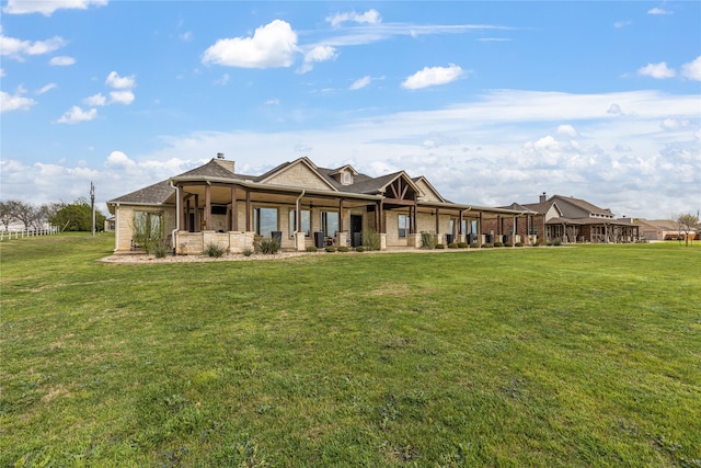 rear view of house featuring a lawn