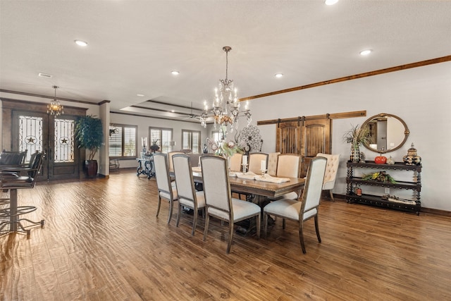 dining room featuring a textured ceiling, a barn door, dark hardwood / wood-style floors, crown molding, and ceiling fan