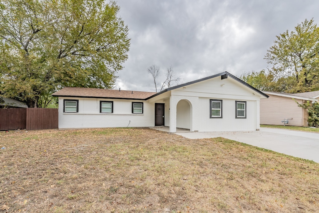 ranch-style house with a patio area and a front lawn