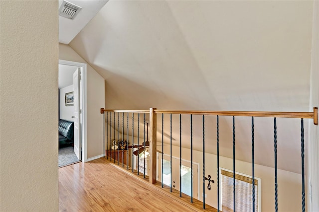 hallway featuring lofted ceiling and hardwood / wood-style flooring