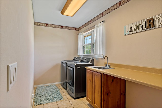 washroom with light tile patterned floors, separate washer and dryer, sink, and cabinets