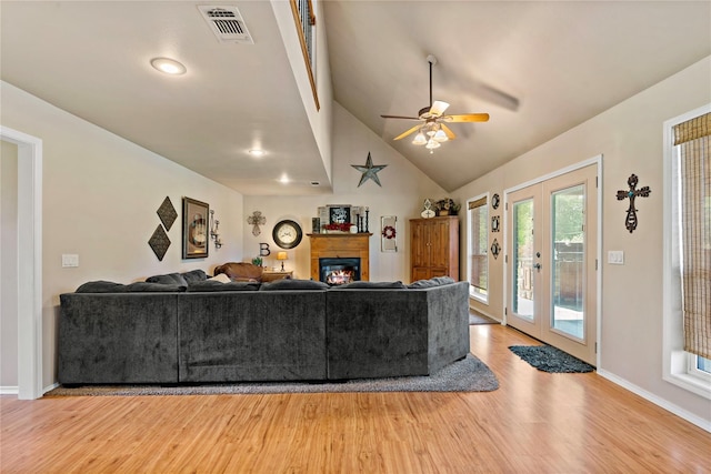 living room with french doors, light hardwood / wood-style floors, ceiling fan, and high vaulted ceiling