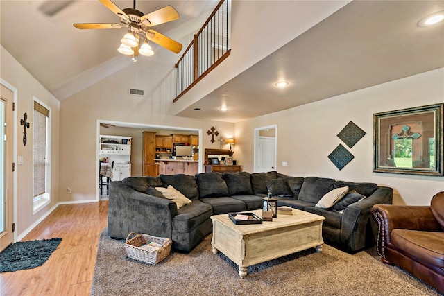 living room with high vaulted ceiling, light wood-type flooring, and ceiling fan