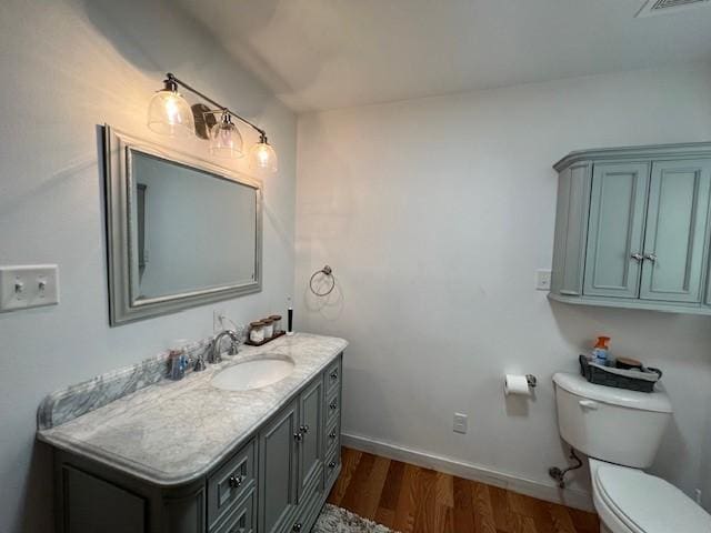 bathroom featuring toilet, vanity, and wood-type flooring