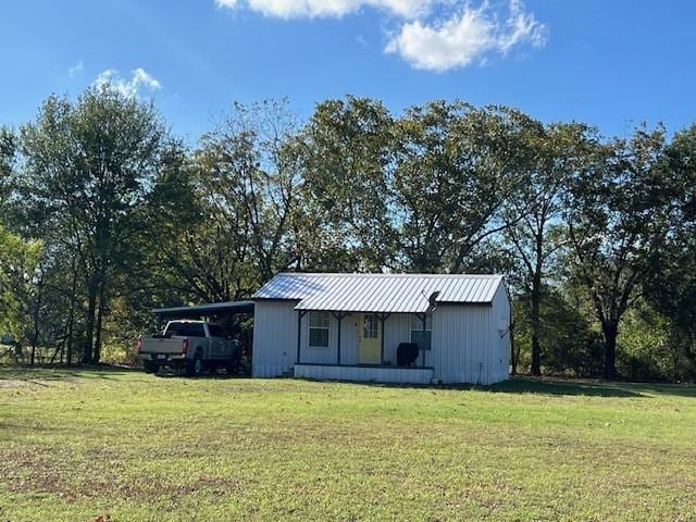 view of outdoor structure with a lawn and a carport