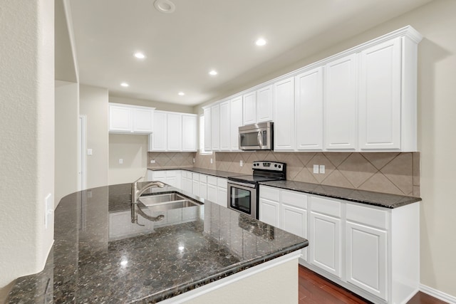 kitchen with white cabinetry, sink, appliances with stainless steel finishes, backsplash, and dark wood-type flooring