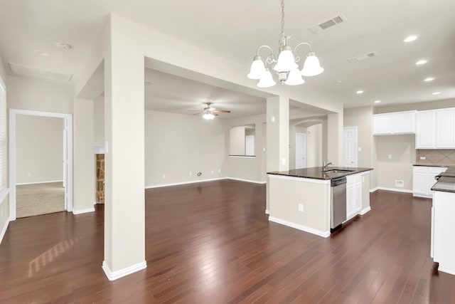 kitchen with ceiling fan with notable chandelier, dark wood-type flooring, pendant lighting, dishwasher, and white cabinetry