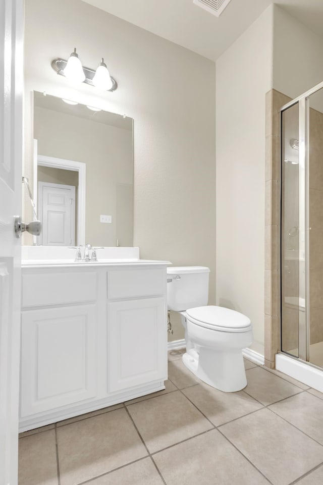 bathroom with toilet, vanity, tile patterned flooring, and a shower with door