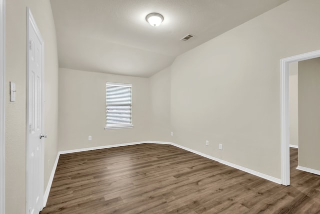 unfurnished bedroom featuring dark wood-type flooring and lofted ceiling