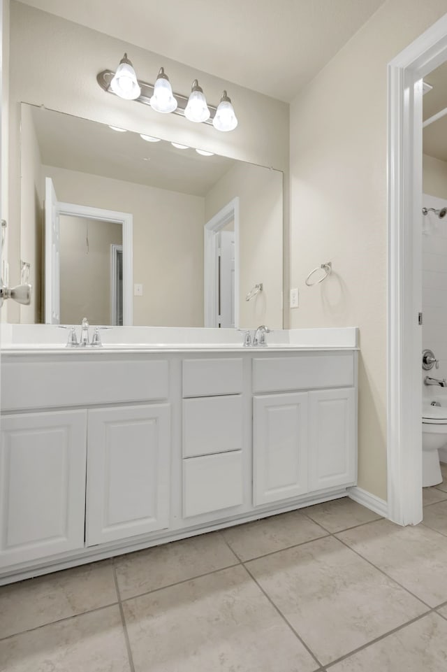 bathroom with toilet, vanity, and tile patterned flooring