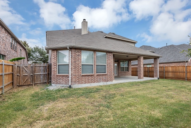 back of house with a lawn and a patio