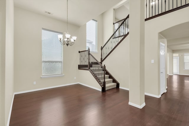 staircase featuring hardwood / wood-style flooring and a notable chandelier