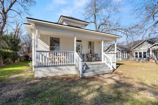 bungalow featuring covered porch and a front yard