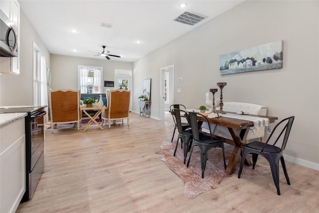 dining area with ceiling fan and light wood-type flooring