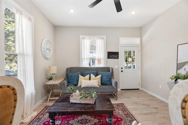 sitting room with ceiling fan and light wood-type flooring