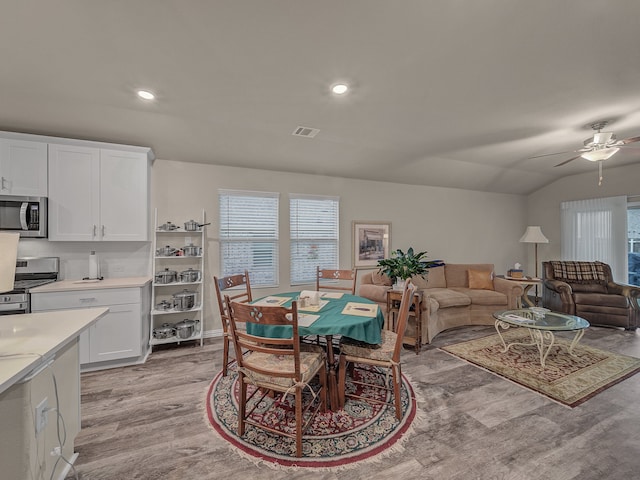 dining room featuring light hardwood / wood-style floors, ceiling fan, and lofted ceiling