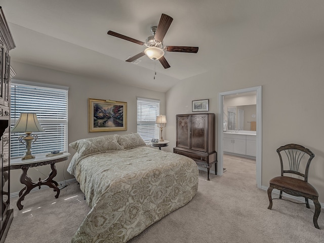 carpeted bedroom with connected bathroom, vaulted ceiling, and ceiling fan