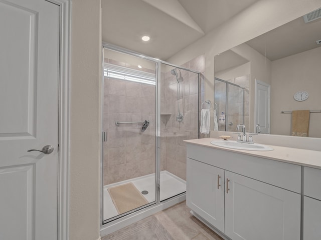 bathroom featuring walk in shower and vanity