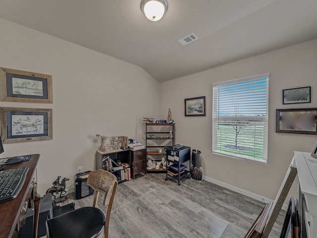 home office with light hardwood / wood-style floors and vaulted ceiling