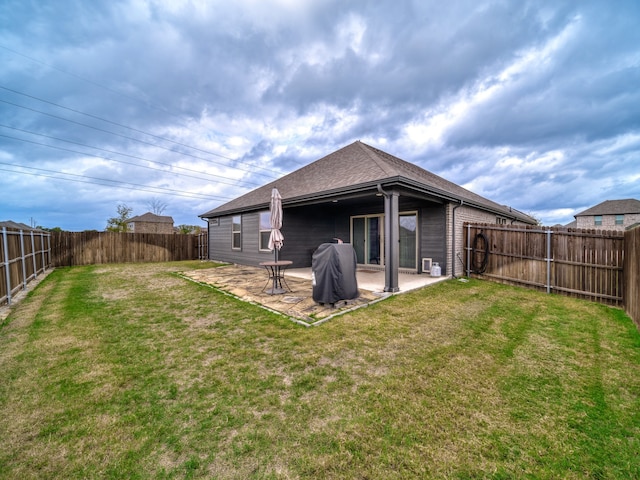 rear view of house with a lawn and a patio area