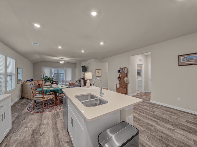 kitchen featuring a center island with sink, sink, ceiling fan, white cabinetry, and light hardwood / wood-style flooring