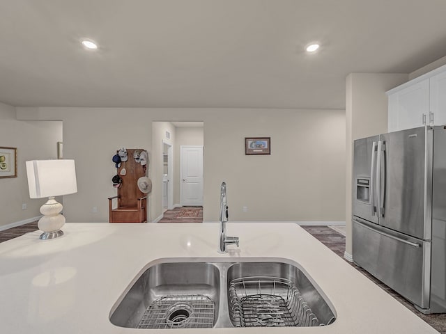 kitchen with dark wood-type flooring, sink, and stainless steel fridge with ice dispenser