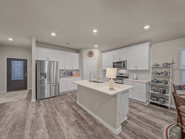 kitchen featuring stainless steel appliances, light hardwood / wood-style floors, white cabinetry, and sink