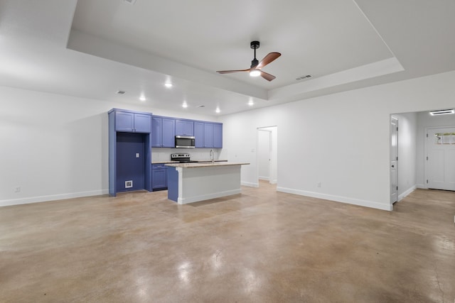 kitchen featuring stainless steel appliances, sink, a tray ceiling, and blue cabinets