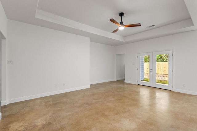 unfurnished room featuring french doors, ceiling fan, and a raised ceiling