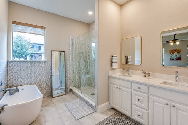 bathroom with tile walls, tile patterned floors, vanity, plus walk in shower, and ceiling fan