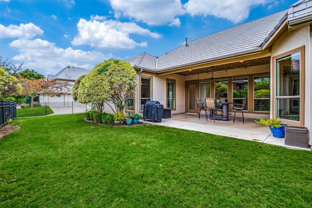 back of property with a lawn and a patio area