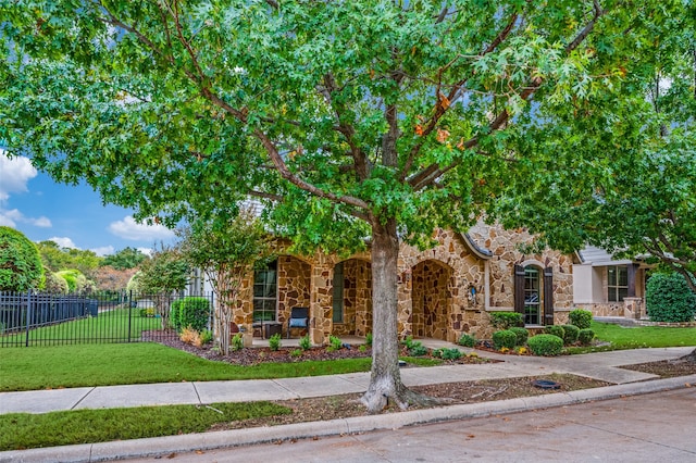 view of property hidden behind natural elements featuring a front lawn