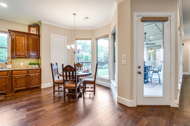 dining space featuring ornamental molding, dark hardwood / wood-style flooring, and a chandelier