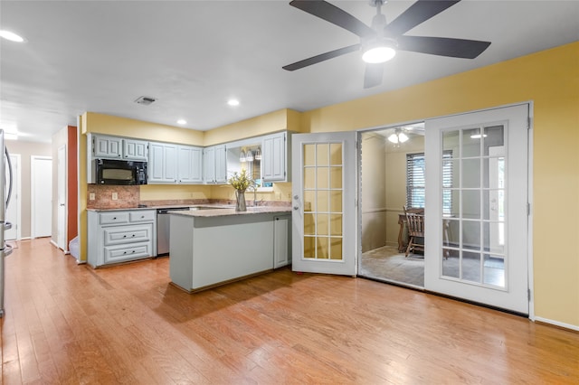 kitchen featuring ceiling fan, stainless steel appliances, tasteful backsplash, kitchen peninsula, and light wood-type flooring