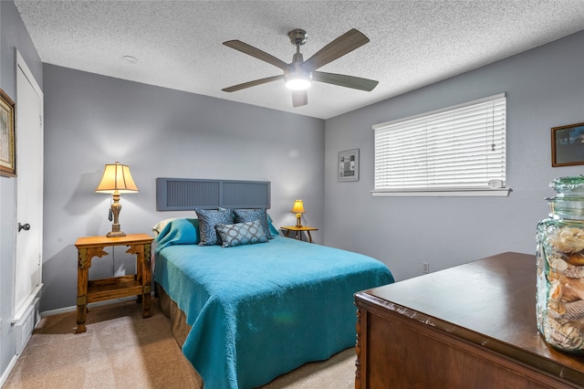 carpeted bedroom with ceiling fan and a textured ceiling