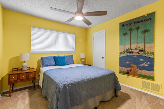 carpeted bedroom with ceiling fan and a textured ceiling