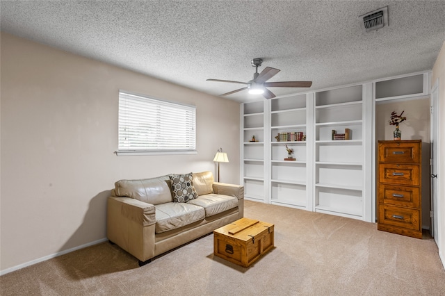 living room with ceiling fan, carpet flooring, and a textured ceiling