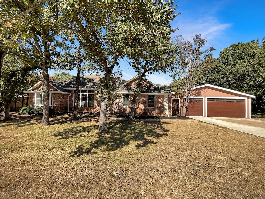 single story home featuring a garage and a front lawn