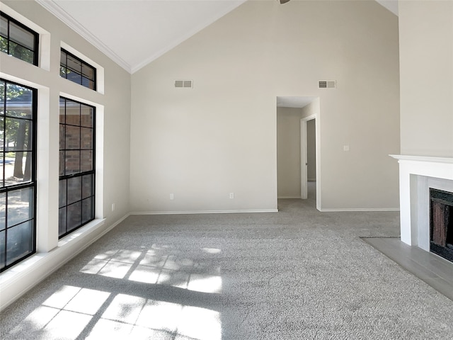 unfurnished living room featuring high vaulted ceiling, light carpet, and crown molding