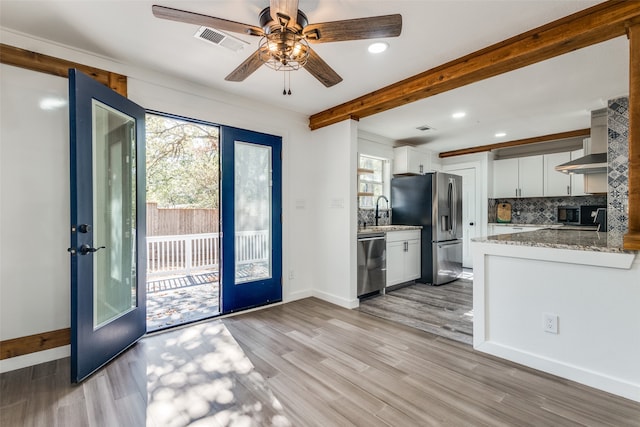 kitchen featuring appliances with stainless steel finishes, french doors, light hardwood / wood-style floors, and white cabinets