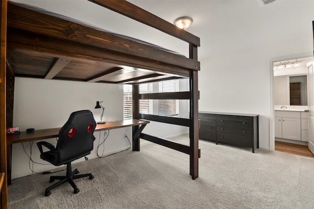 carpeted office with wood ceiling, sink, and beam ceiling