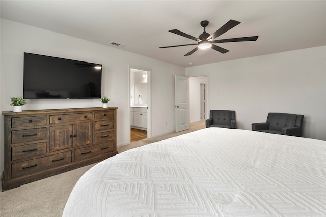 carpeted bedroom with ensuite bathroom and ceiling fan