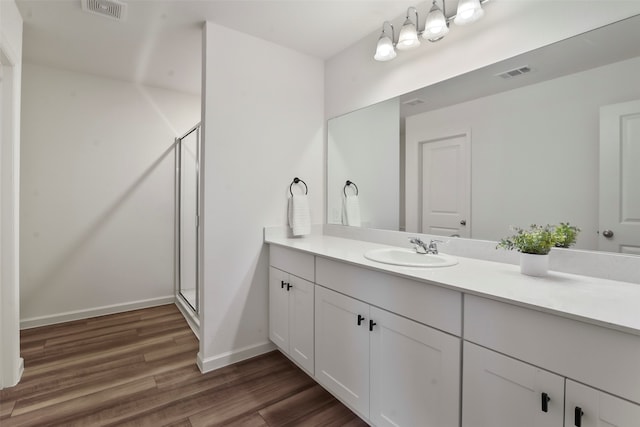 bathroom featuring vanity, hardwood / wood-style flooring, and a shower with shower door