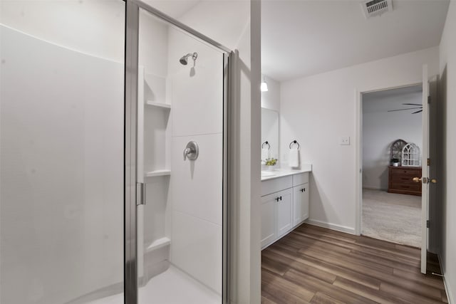 bathroom with ceiling fan, a shower with shower door, vanity, and wood-type flooring