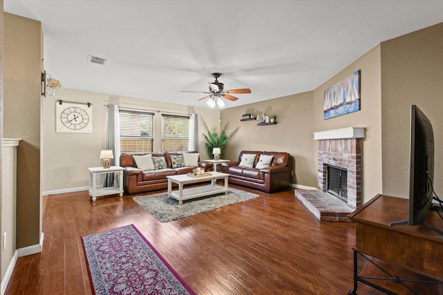 living room featuring a fireplace, dark hardwood / wood-style floors, and ceiling fan