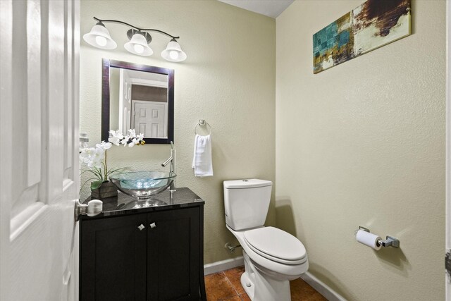 bathroom with toilet, vanity, and tile patterned floors